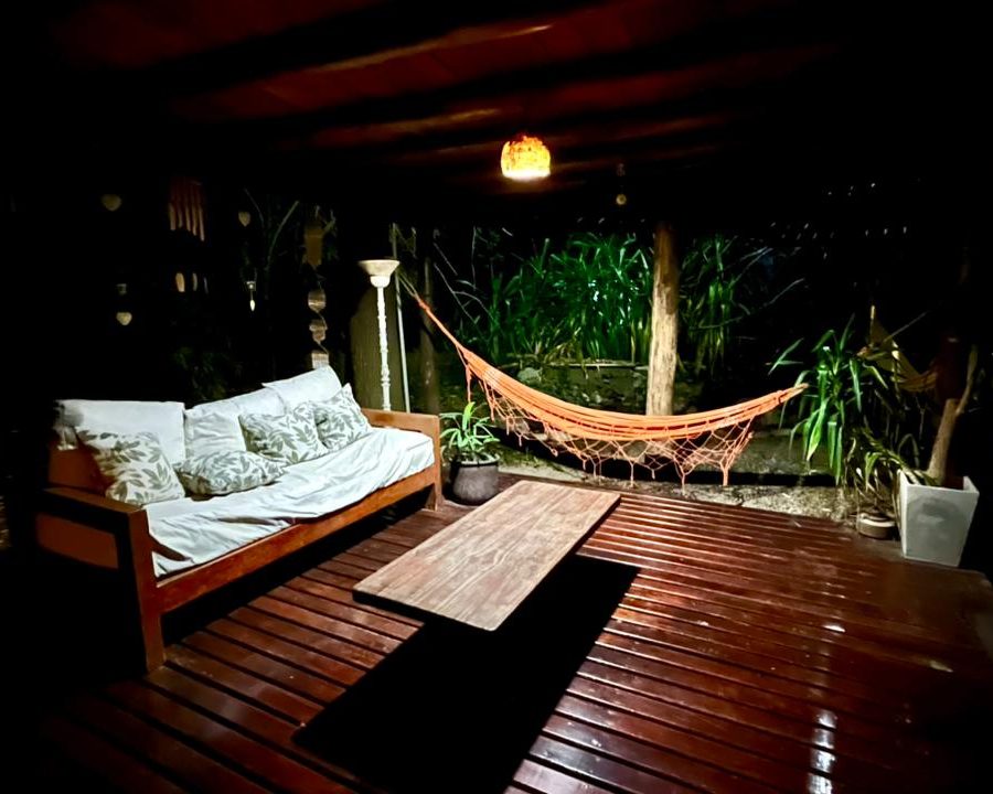 Deck con hamaca paraguaya y sillón iluminados de noche
