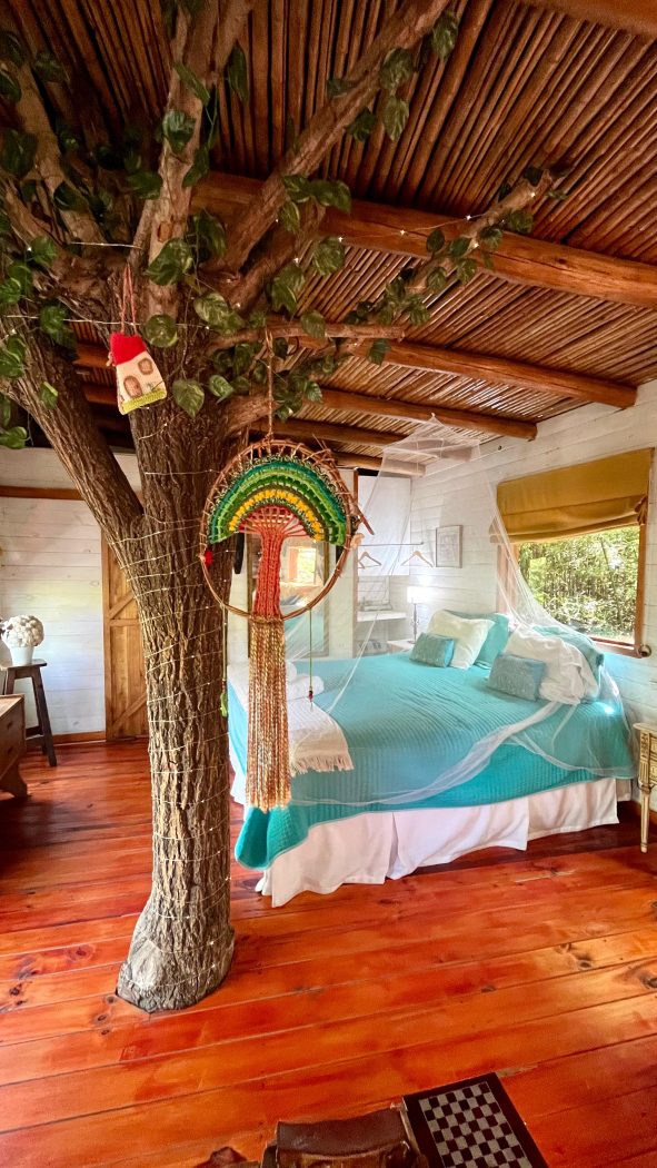 Dormitorio con el tronco de un árbol atravesando la habitación