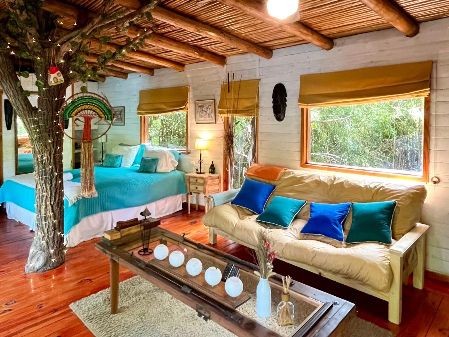 Living con el tronco de un árbol atravesando la cabaña