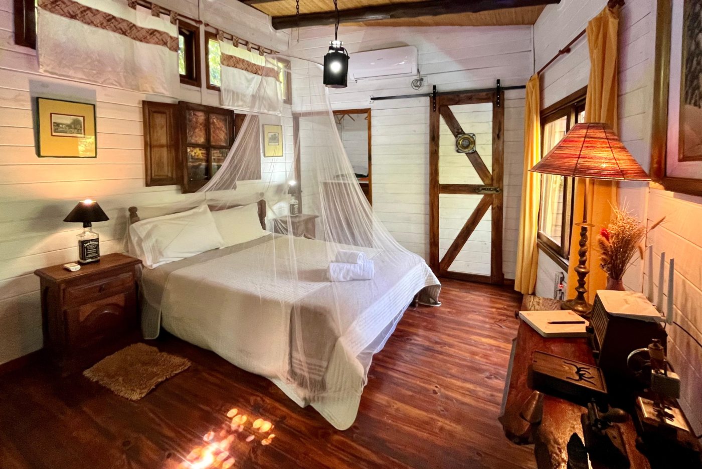 Cama con mosquitero y puertas de madera