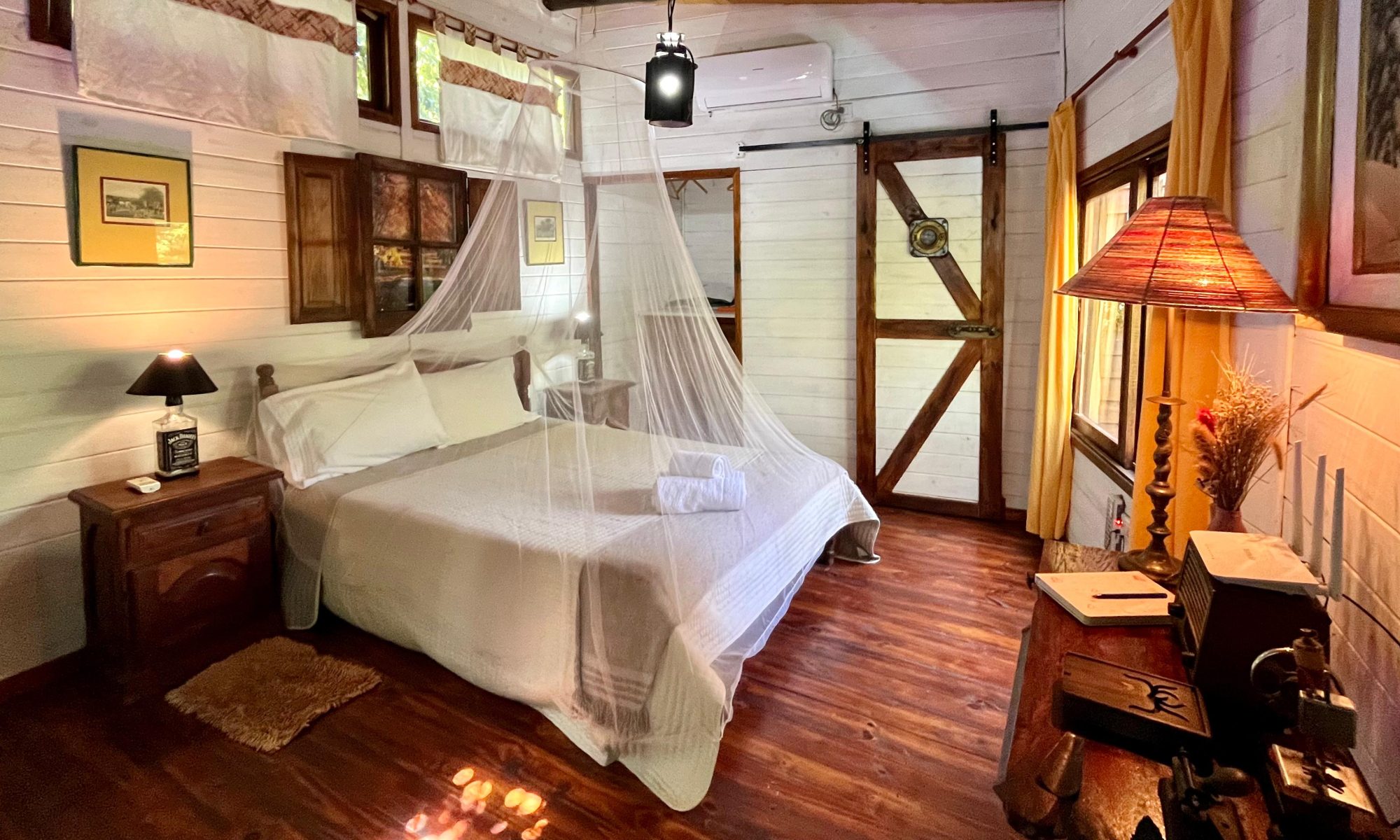 Cama con mosquitero y puertas de madera