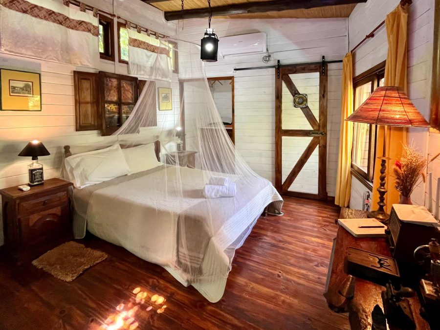 Cama con mosquitero y puertas de madera