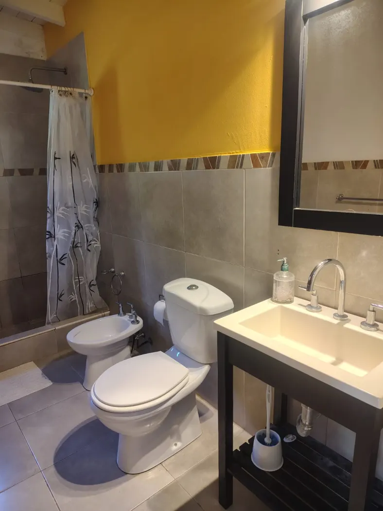 Baño de la suite El Jacarandá, con bañera, bidet y ventana al parque