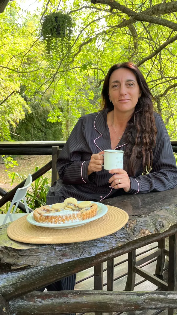 Desayuno con café y tarta en el deck, con el bosque de fondo